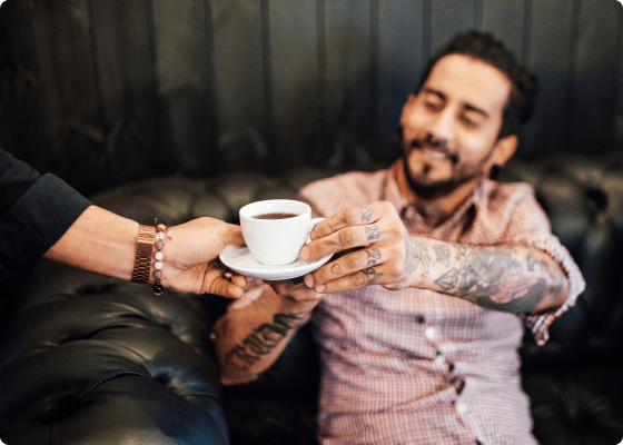 two people holding tea mug in hand 