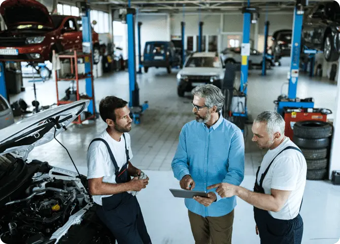 cliente che parla con i meccanici in un'autofficina