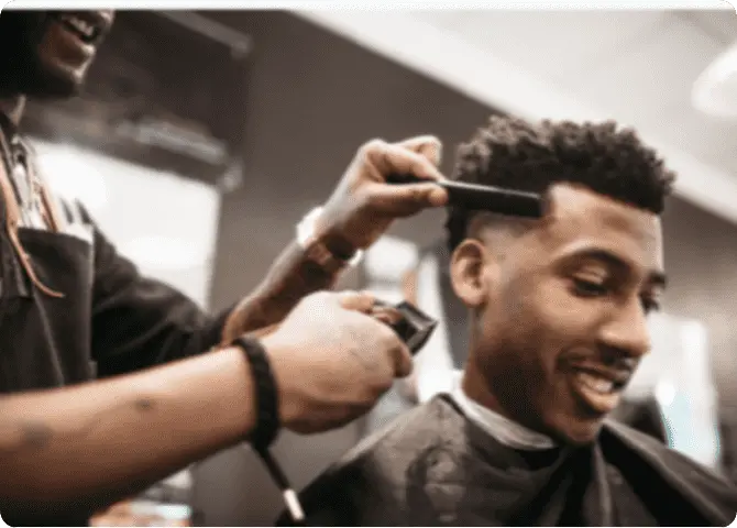 Ein Barbier verpasst einem Kunden einen Haarschnitt