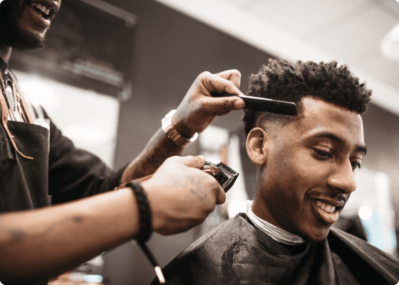 Um barbeiro a cortar o cabelo ao seu cliente