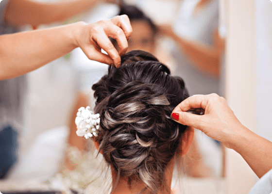 Eine Braut bekommt an ihrem Hochzeitstag die Haare gemacht