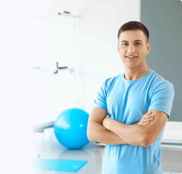 Fit man with a smile standing in a yoga room