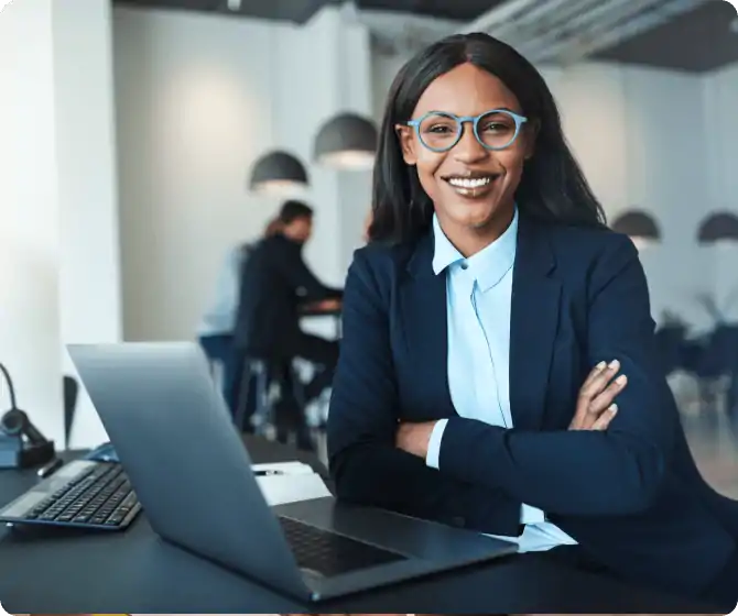 A smiling woman in blue spectacles and suit