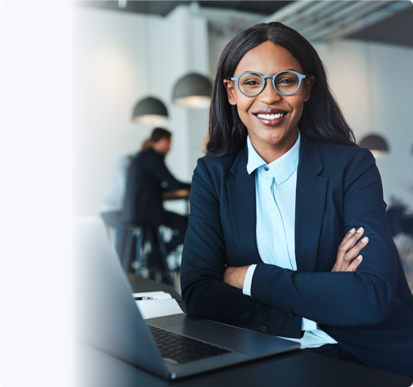 A smiling woman in blue spectacles and suit