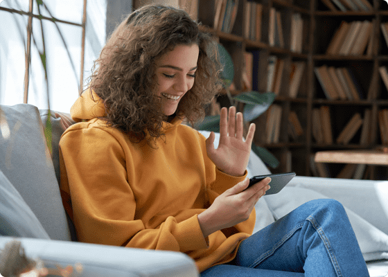 Curly haired girl waving on a video call