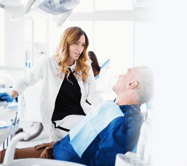 Dentist briefing her male patient on the treatment