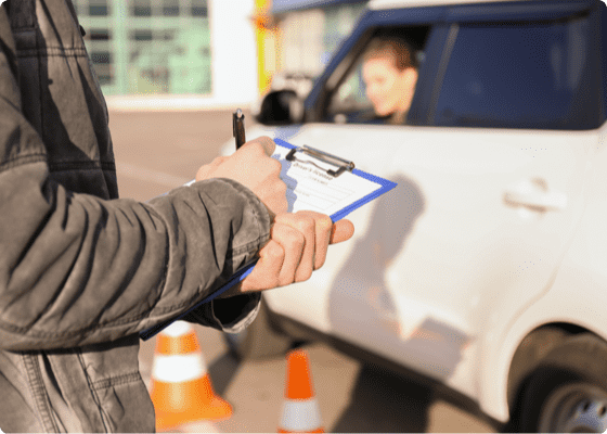 Ein DMV-Lehrer unterschreibt ein Führerscheinprüfungsformular