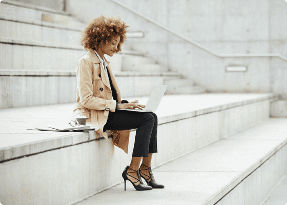 Una donna seduta sulle scale con un laptop
