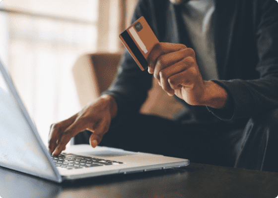 A hand with swipe card and a laptop