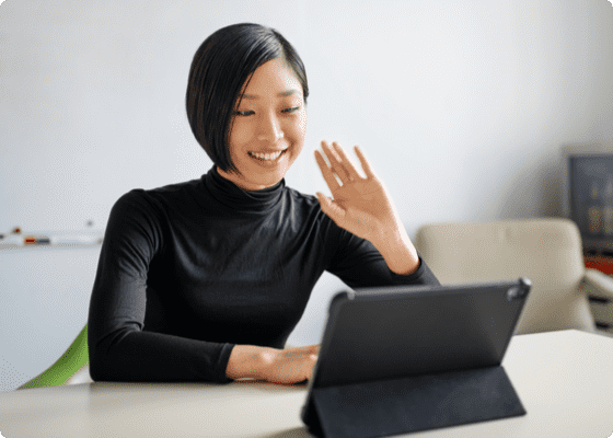 Uma mulher alegre acenando as mãos para o tablet