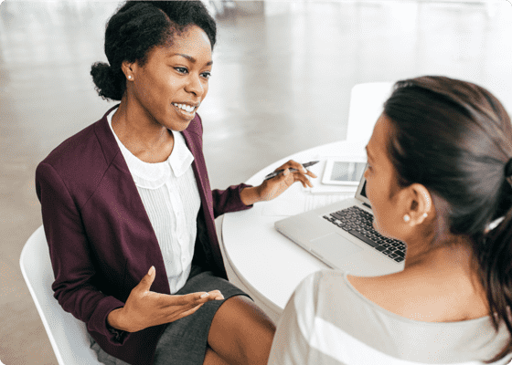 One lady discussing with another on a desk