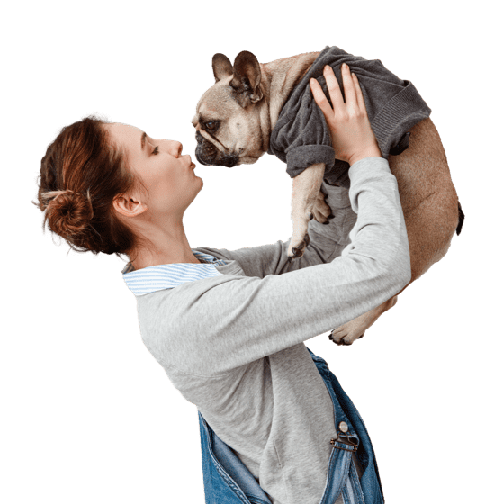 A lady carrying and kissing her dog