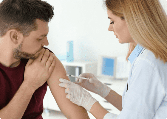 médico a vacinar um doente