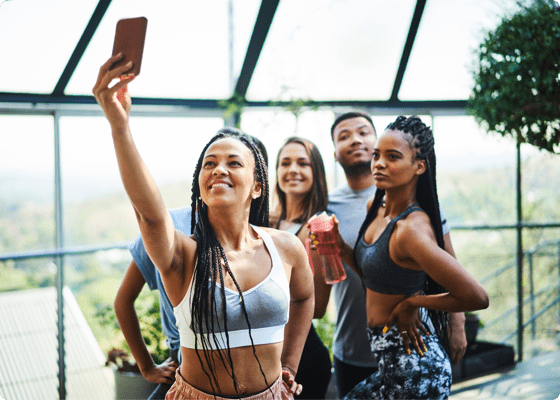 Einige wenige Leute posen, während eine Frau ein Selfie macht