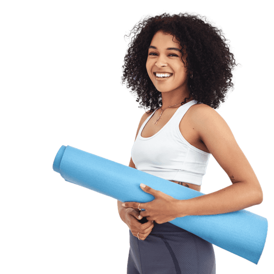 Happy woman standing with yoga mat