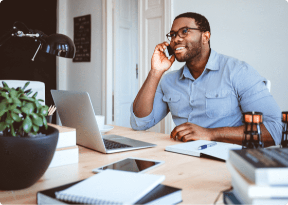 Un homme en chemise bleue qui parle tout en travaillant