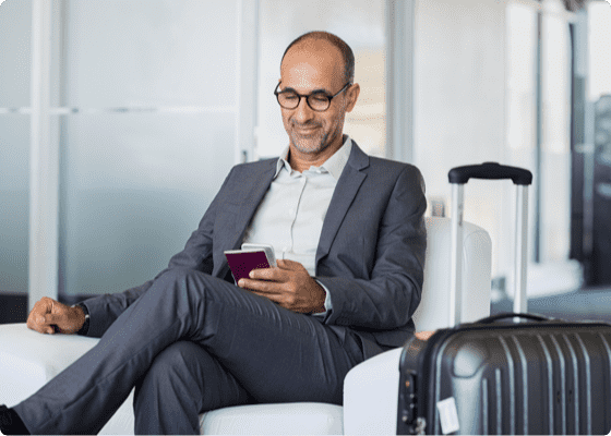 Un uomo che guarda il suo cellulare in una sala d'attesa