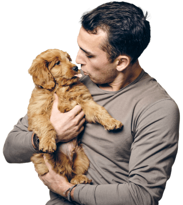 man holding and looking his dog